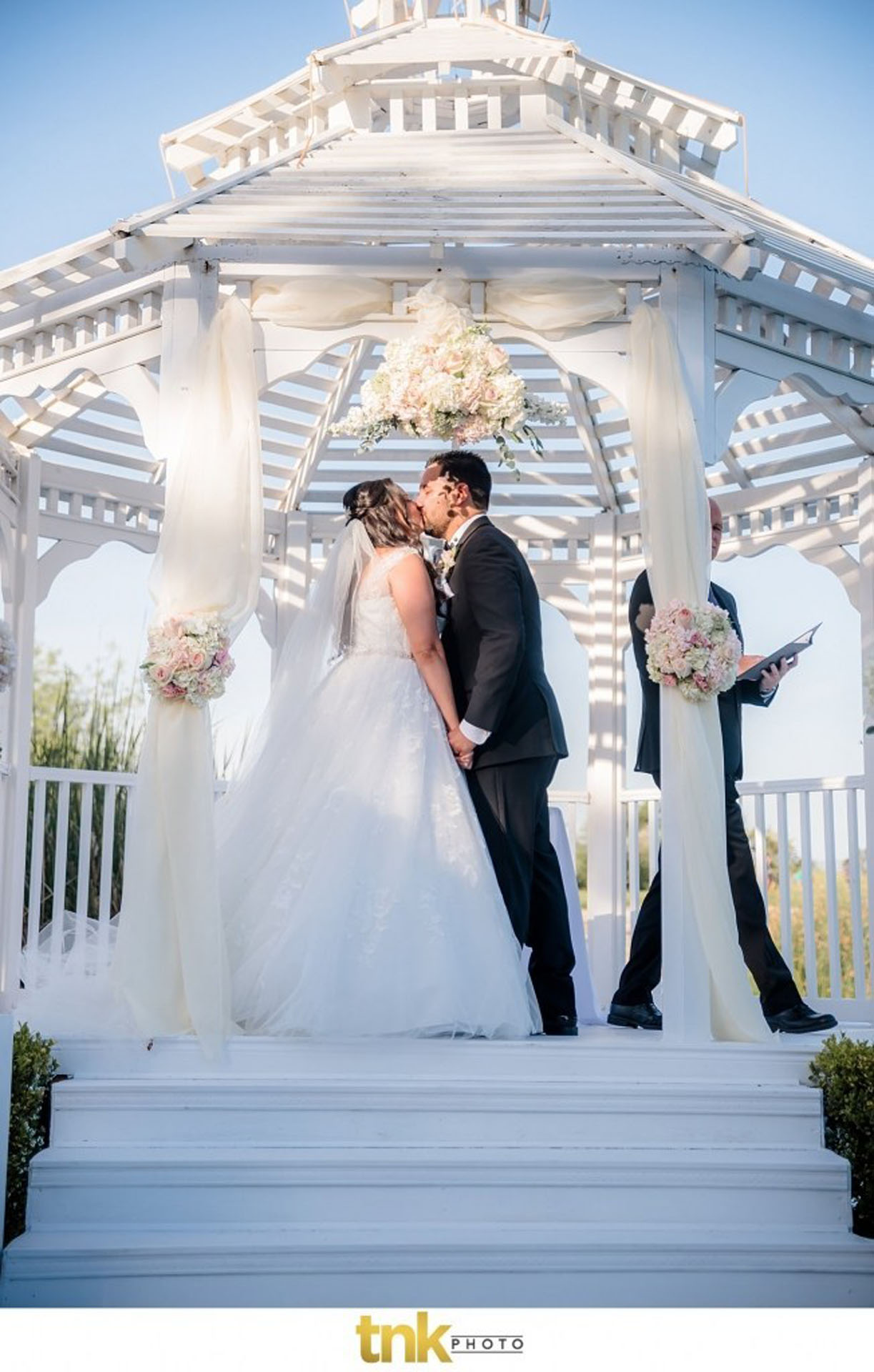 Wedding couple kissing at outdoor ceremony 